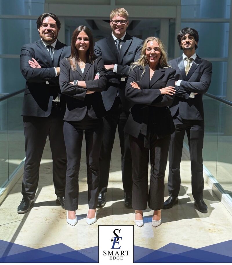 The Smart Edge Inc. team of five marketing professionals standing together in a sunlit office atrium